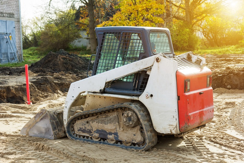 Mini excavator bobcat standing at construction site